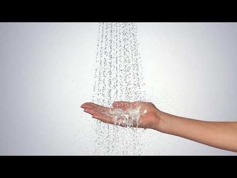 Hansgrohe Croma Select S hand shower with water flowing onto a hand, white and chrome finish, multi spray modes.