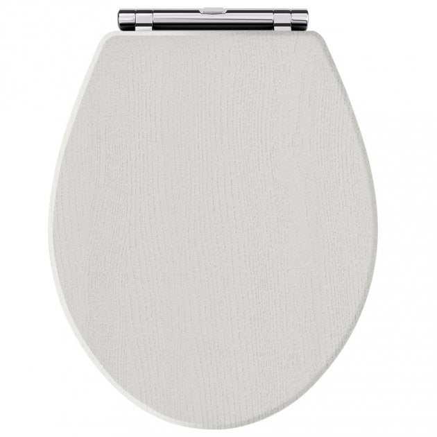 Toilet seat with traditional chrome hinges in timeless sand shade, featuring soft close mechanism for quiet closing.