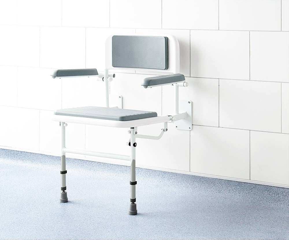 Impey Deluxe padded fold down shower seat with adjustable height and durable powder coated frame mounted on tiled bathroom wall