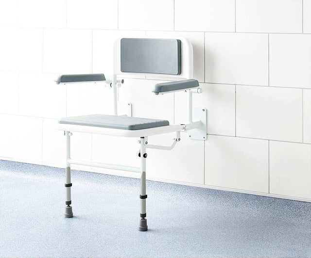Impey Deluxe padded fold down shower seat with adjustable height and durable powder coated frame mounted on tiled bathroom wall