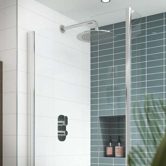 Nuie Binsey dual handle thermostatic concealed shower valve in chrome installed in modern bathroom with tiled walls and rain showerhead