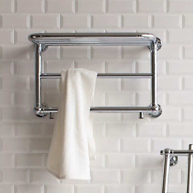 Chrome heated towel rail 400mm high x 640mm wide with warm towel hanging on white tiled bathroom wall.