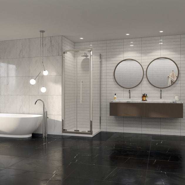 Modern bathroom with Coram 8mm Plain Glass chrome framed bi-fold shower door, freestanding bathtub, and double round mirrors above wall-mounted vanity