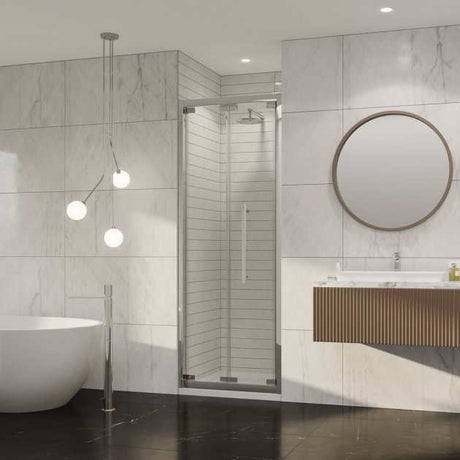 Coram 8mm plain glass chrome framed bi-fold shower door installed in modern bathroom with marble wall and round mirror