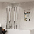 Coram 4mm glass five folding clear bath screen installed on white bathtub with tiled bathroom wall and recessed shelves