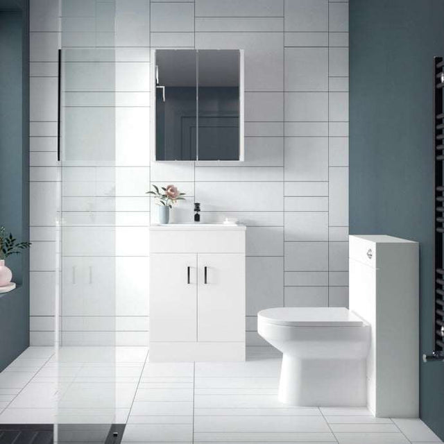 Modern bathroom with Nuie gloss white wall WC toilet unit, vanity sink, and mirrored cabinet