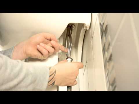Man installing Bristan Smile Clicker Waste chrome basin mixer tap on bathroom wall