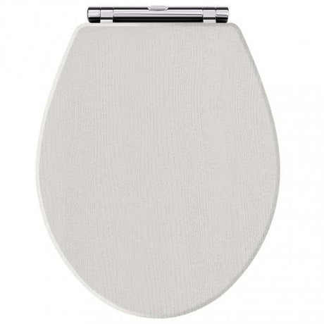 Toilet seat with traditional chrome hinges in timeless sand shade, featuring soft close mechanism for quiet closing.