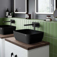 Matte black Nuie Square sit-on vessel countertop basin 455mm wide with modern wall-mounted faucet and green tiled backsplash.