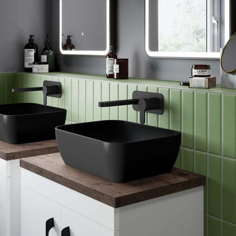 Matte black Nuie Square sit-on vessel countertop basin 455mm wide with modern wall-mounted faucet and green tiled backsplash.