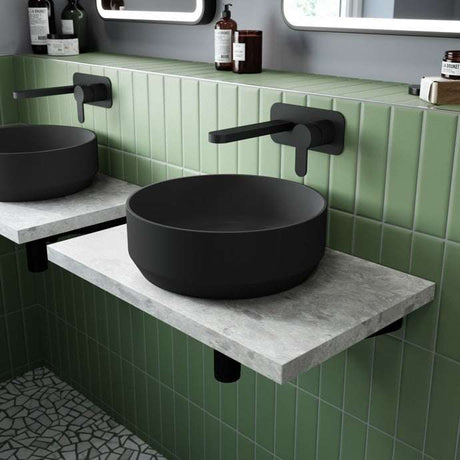 Matt black Nuie Round Sit-On Vessels countertop basin 350mm wide in modern bathroom with green tiled wall and wall-mounted black faucet