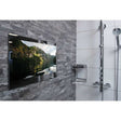 ProofVision 43 inch premium waterproof bathroom TV with mirror finish mounted on grey tiled wall next to showerhead and chrome shower shelf