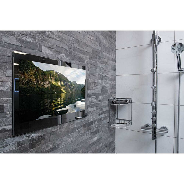 ProofVision 43 inch premium waterproof bathroom TV with mirror finish mounted on grey tiled wall next to showerhead and chrome shower shelf