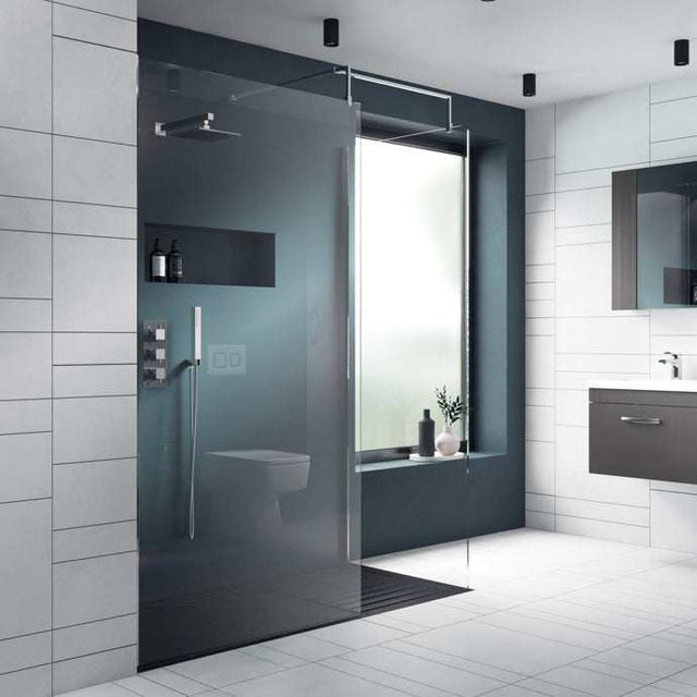 Nuie 8mm thick glass wet room screen with chrome support bar in modern bathroom setting
